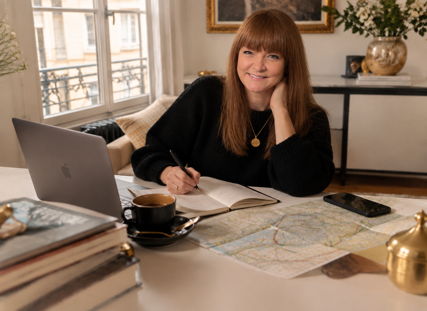 Emma Jennings in her retreat office with notebooks open in front of her