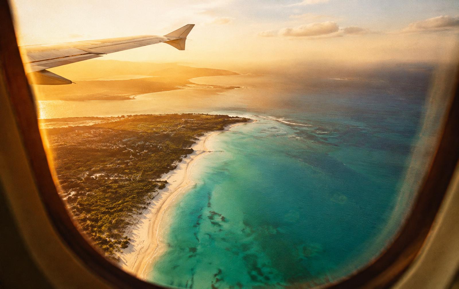 View of a turquoise coastline from an aeroplane window